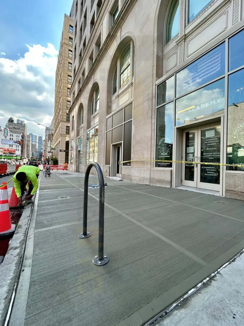 Pave Guard NYC crew member finishing a commercial sidewalk outside an office building