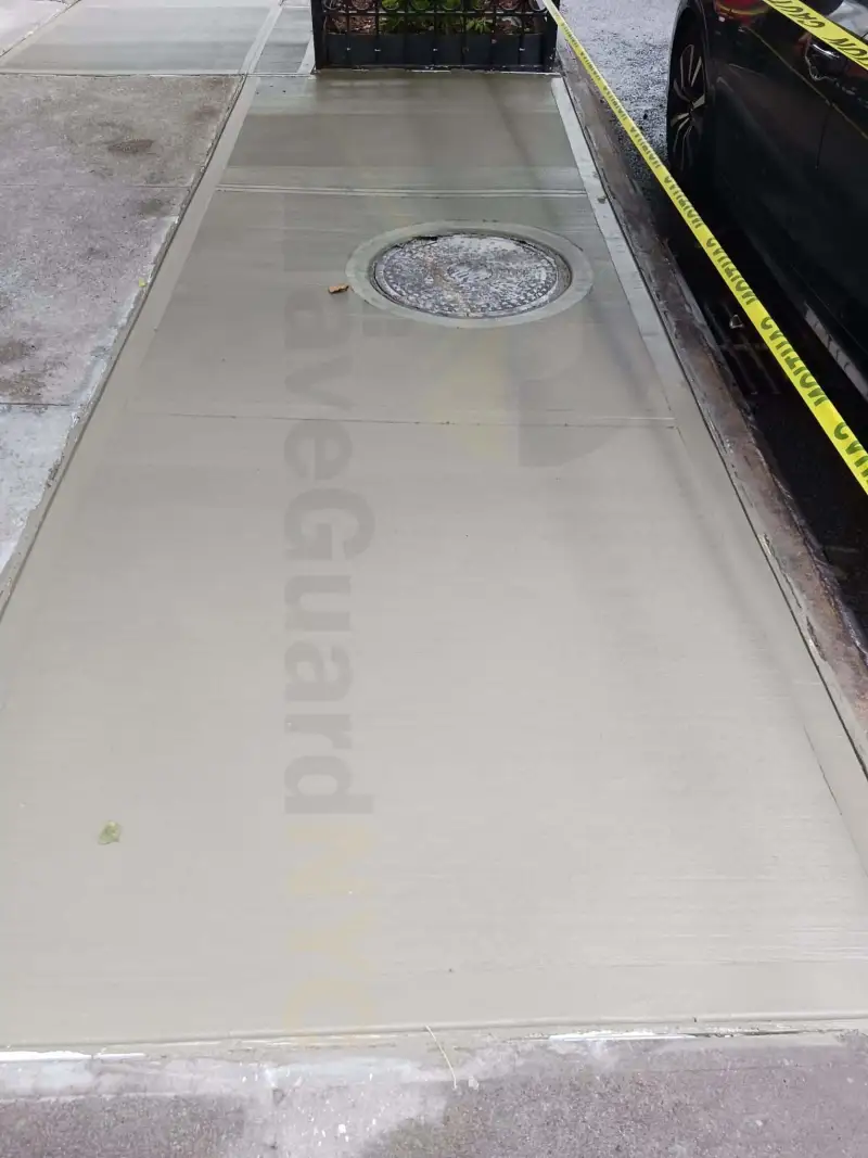 New sidewalk poured around a utility cover