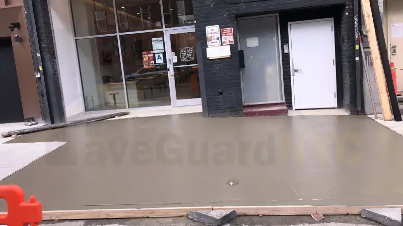 New concrete sidewalk in front of a storefront entrance